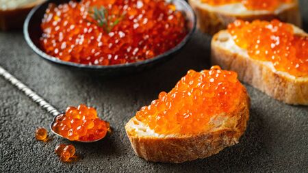 Delicious Sandwiches with red caviar on a dark concrete background.の写真素材