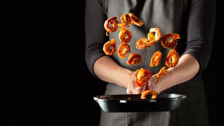Professional chef prepares shrimps or langoustines with spices. Cooking mediterranean seafood, healthy vegetarian food on a dark background. With copy space for text.の写真素材