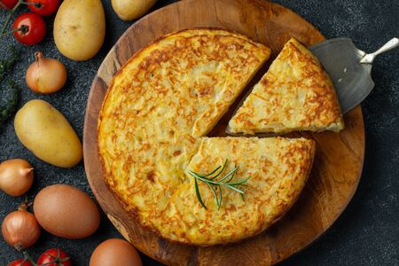 Spanish omelette with potatoes and onion, typical Spanish cuisine. Tortilla espanola. Rustic dark background. Top view.の写真素材