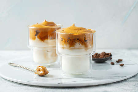 Dalgona coffee. Iced fluffy creamy whipped trend drink with coffee foam and milk.の写真素材