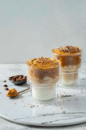 Dalgona coffee. Iced fluffy creamy whipped trend drink with coffee foam and milk.の写真素材