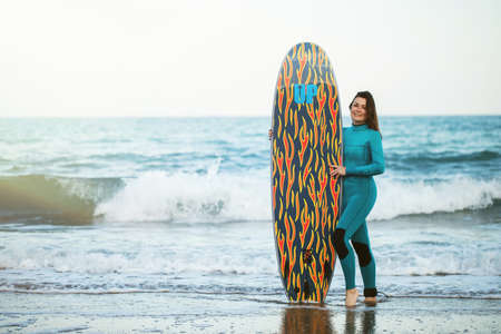 Surfer girl walking with board on the sandy beach. Surfer female.の写真素材