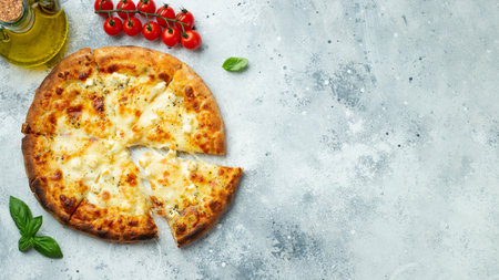 Italian pizza four cheeses with stretching cheese and basil on a light concrete background. Top view with copy space.の写真素材