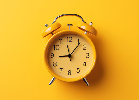 Top view of the yellow alarm clock on the yellow background with a free space for text. Getting up early in the morning. Wake up with a great moodの素材