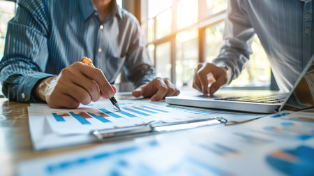Two colleagues discussing data working and tablet, laptop with on on architectural project at construction site at desk in officeの素材