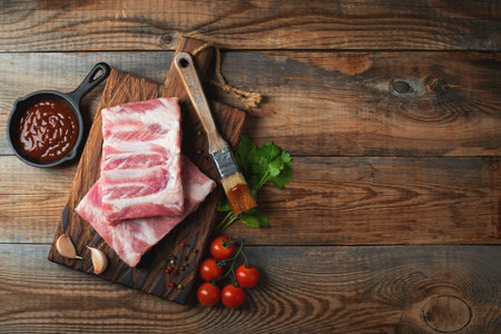Raw pork ribs with spices, salt and rosemary on dark wooden background. top view with copy space.の写真素材