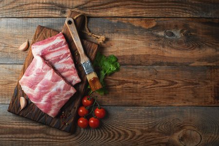 Raw pork ribs with spices, salt and rosemary on dark wooden background. top view with copy space.の写真素材