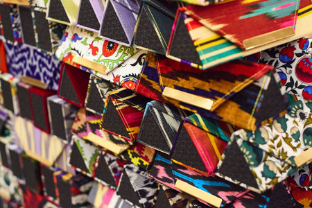 Close-up of colorful handmade cases (likely for glasses or pens) featuring traditional Eastern patterns. Handicraft exhibition in Tashkent with bright colors and textural detailsの写真素材