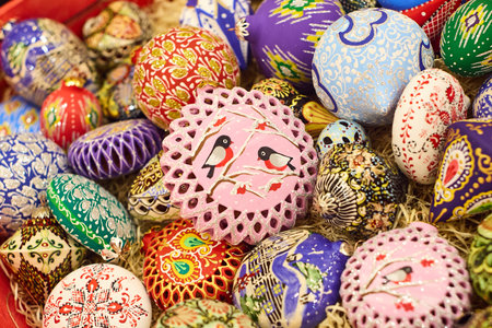 A close-up of a variety of colorfully patterned handmade Christmas tree decorations on display at a...