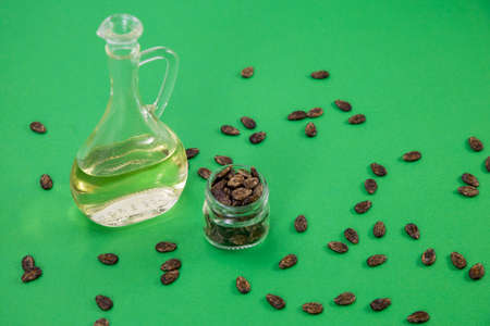 Watermelon oil from seeds in a bottle, seeds are scattered around, a jar full of seeds on a green backgroundの写真素材