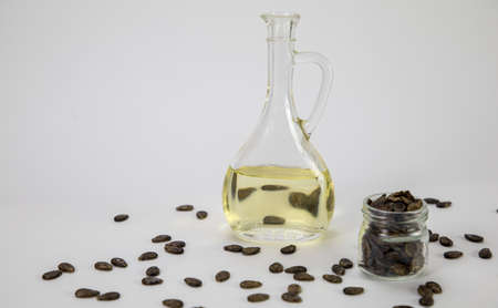 Watermelon oil from seeds in a bottle, seeds are scattered around, a jar full of seeds on a white backgroundの写真素材