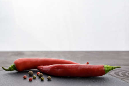 red chili on a stone plate with allspice on white backgroundの写真素材