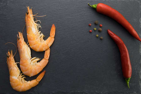 boiled shrimp on a stone plate and red chili pepperの写真素材