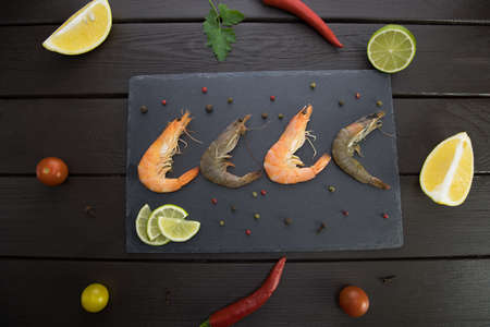 shrimp on a stone plate around vegetablesの写真素材