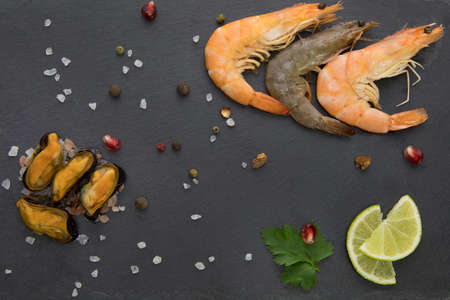 mussels with shrimp on a stone plate with lime and red chili pepperの写真素材