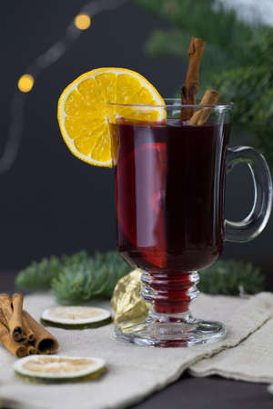 winter treats, a mug of warm wine with an orange, and cookies, ingredients on a wooden brown table. Traditional hot drink for Christmas, in the background Christmas composition.の写真素材