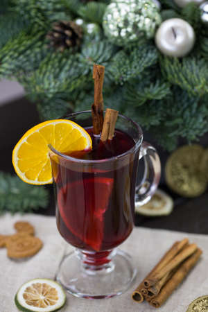 winter treats, a mug of warm wine with an orange, and cookies, ingredients on a wooden brown table. Traditional hot drink for Christmas, in the background Christmas composition.の写真素材