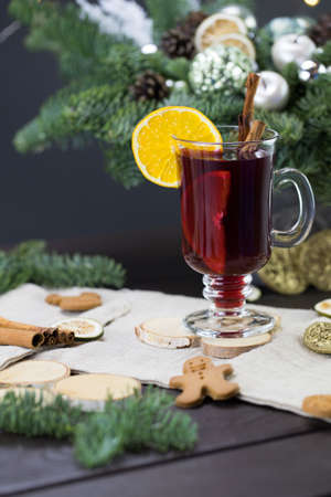 winter treats, a mug of warm wine with an orange, and cookies, ingredients on a wooden brown table. Traditional hot drink for Christmas, in the background Christmas composition.の写真素材