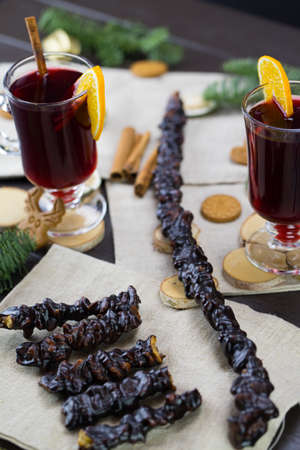 winter treats, a mugs of warm wine with an orange, and cookies, ingredients on a wooden brown table. Traditional hot drink for Christmas. Churchelaの写真素材
