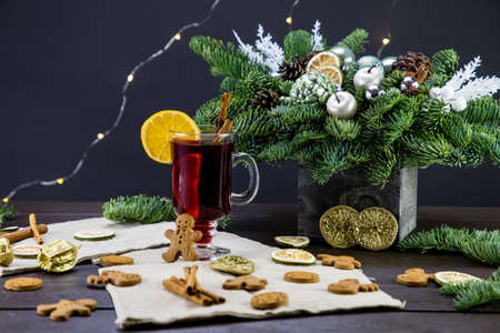 winter treats, a mug of warm wine with an orange, and cookies, ingredients on a wooden brown table. Traditional hot drink for Christmas, in the background Christmas composition.の写真素材