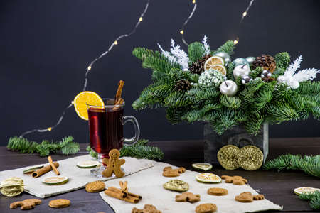 winter treats, a mug of warm wine with an orange, and cookies, ingredients on a wooden brown table. Traditional hot drink for Christmas, in the background Christmas composition.の写真素材