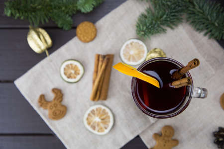 winter treats, a mug of warm wine with an orange, and cookies, ingredients on a wooden brown table. Traditional hot drink for Christmas, in the background Christmas composition.の写真素材