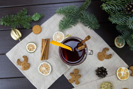 winter treats, a mug of warm wine with an orange, and cookies, ingredients on a wooden brown table. Traditional hot drink for Christmas, in the background Christmas composition.の写真素材