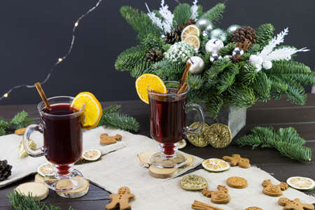 winter treats, a mug of warm wine with an orange, and cookies, ingredients on a wooden brown table. Traditional hot drink for Christmas, in the background Christmas composition.の写真素材