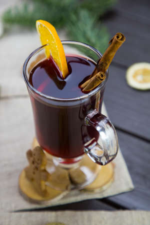 winter treats, a mug of warm wine with an orange, and cookies, ingredients on a wooden brown table. Traditional hot drink for Christmas, in the background Christmas composition.の写真素材