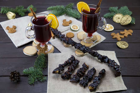 winter treats, a mugs of warm wine with an orange, and cookies, ingredients on a wooden brown table. Traditional hot drink for Christmas. Churchelaの写真素材