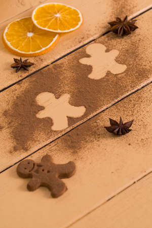 Christmas cookies around cinnamon, on a wooden board.