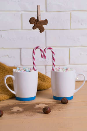Christmas cookies hanging over marshmallow mugs red and white christmas candy cane.の写真素材