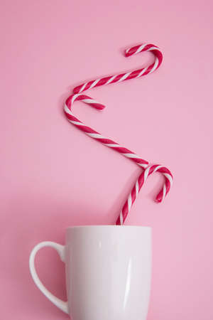in a mug of Christmas candy cane, on a pink background.の写真素材