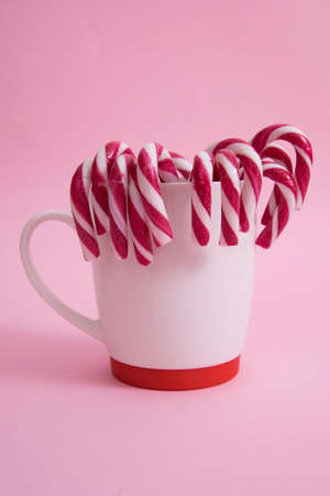 in a mug of Christmas candy cane, on a pink background.の写真素材