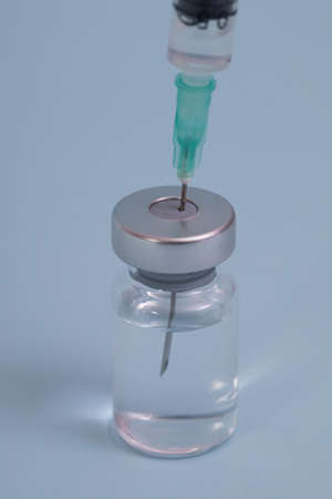Covide-19 vaccine, close up. Administrating medication with medical needle syringe and vaccine injection for patient vaccination in medical hospital. Health and medical concepts.の写真素材