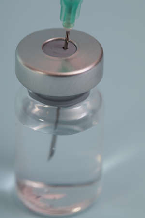 Covide-19 vaccine, close up. Administrating medication with medical needle syringe and vaccine injection for patient vaccination in medical hospital. Health and medical concepts.の写真素材