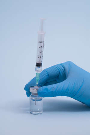Concept fight against virus covid-19 corona virus, scientist in laboratory holding a syringe with liquid vaccines for children or older adults.の写真素材