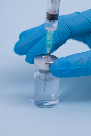 Concept fight against virus covid-19 corona virus, scientist in laboratory holding a syringe with liquid vaccines for children or older adults.の写真素材