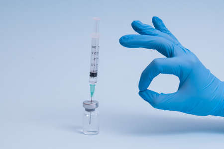 Concept fight against virus covid-19 corona virus, scientist in laboratory holding a syringe with liquid vaccines for children or older adults.の写真素材