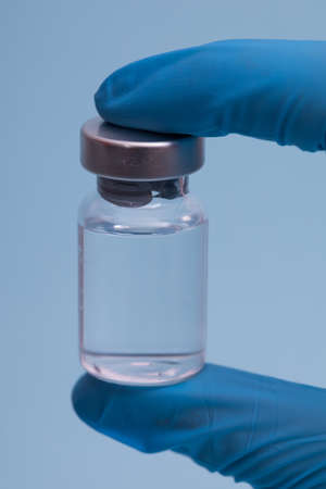 doctor with a stethoscope on shoulder holding syringe and COVID-19 vaccine. Healthcare And Medical...