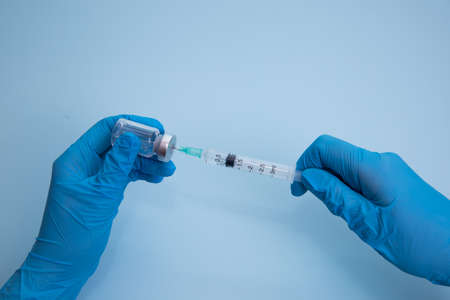 Concept fight against virus covid-19 corona virus, scientist in laboratory holding a syringe with liquid vaccines for children or older adults.の写真素材