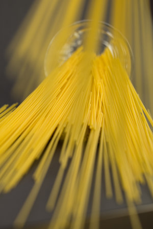 Long macaroni in a mug lies on a blue wooden tableの写真素材