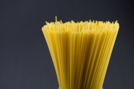 Dry spaghetti pasta in a drinking glass. Dark background. Copy space for your text.の写真素材