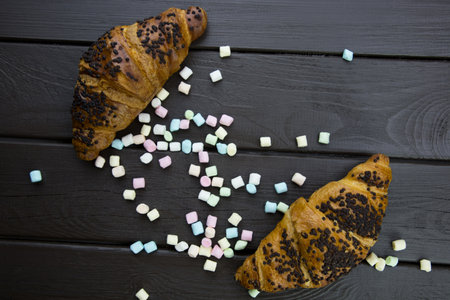 marshmallow and chocolate croissant on a wooden boardの写真素材