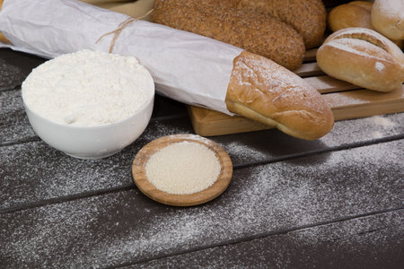 Bakery - gold rustic crusty loaves of bread and buns on black chalkboard background top view.の写真素材