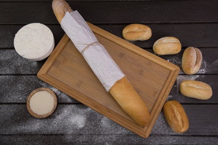 Bakery - gold rustic crusty loaves of bread and buns on black chalkboard background top viewの写真素材