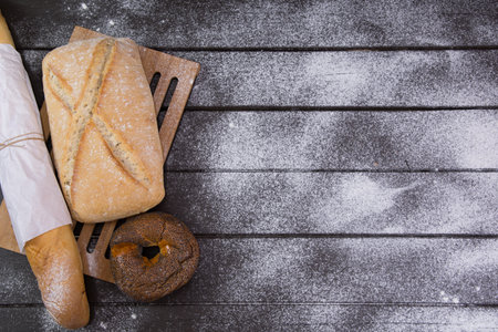 Bakery - gold rustic crusty loaves of bread and buns on black chalkboard background top viewの写真素材