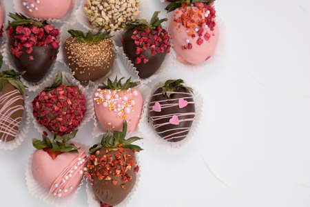 Assorted strawberries in chocolate, sweet dessert, berries in different chocolate and sprinkled with nuts.の写真素材