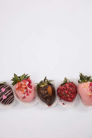 Assorted strawberries in chocolate, sweet dessert, berries in different chocolate and sprinkled with nuts.の写真素材