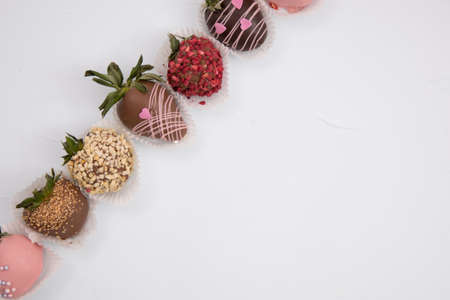 Assorted strawberries in chocolate, sweet dessert, berries in different chocolate and sprinkled with nuts.の写真素材
